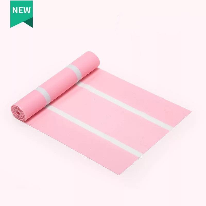 Pink yoga mat with white alignment stripes, partially rolled, ideal for home gym workouts
